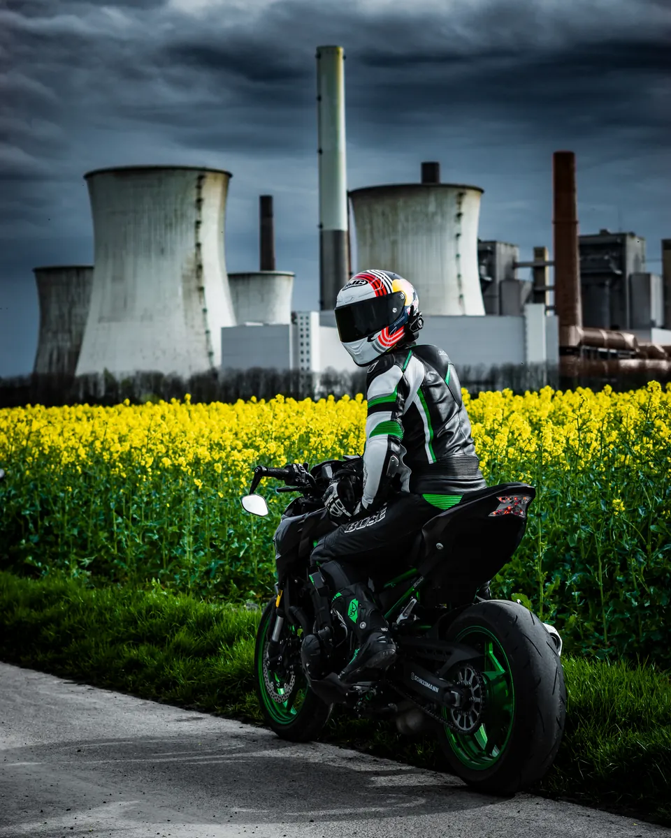 Motorrad im Rapsfeld vor Kühltürmen